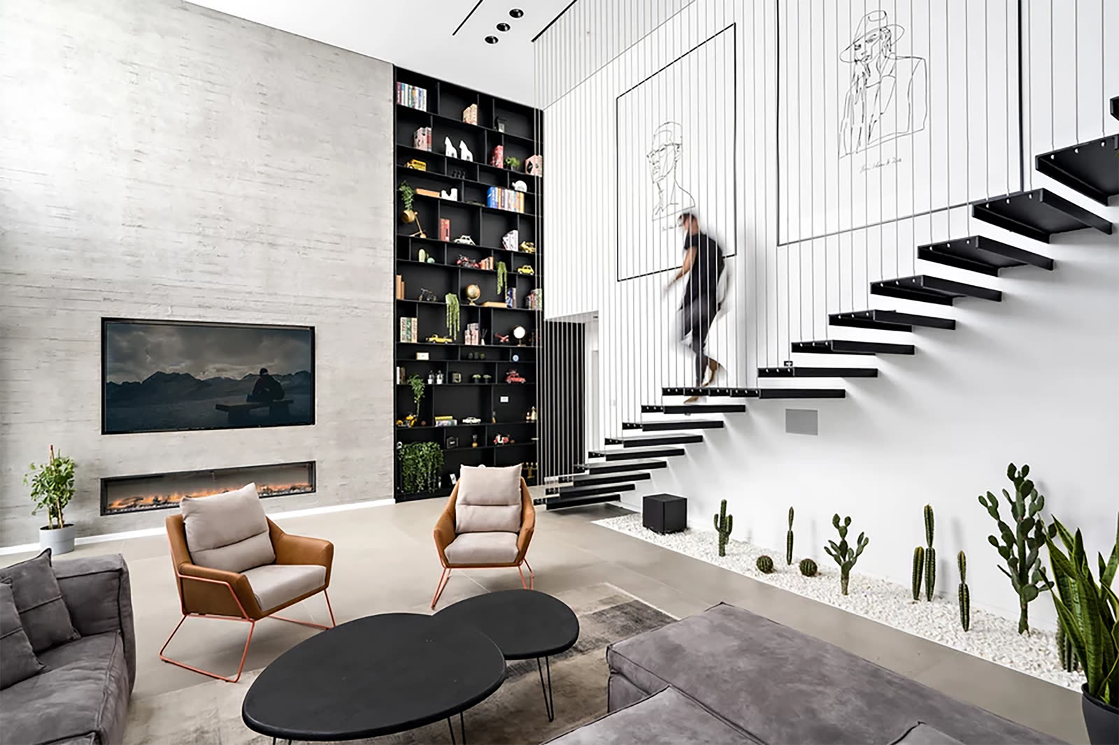 Floating staircase with full-height black built-in library shelving by iKitchen Cabinetry