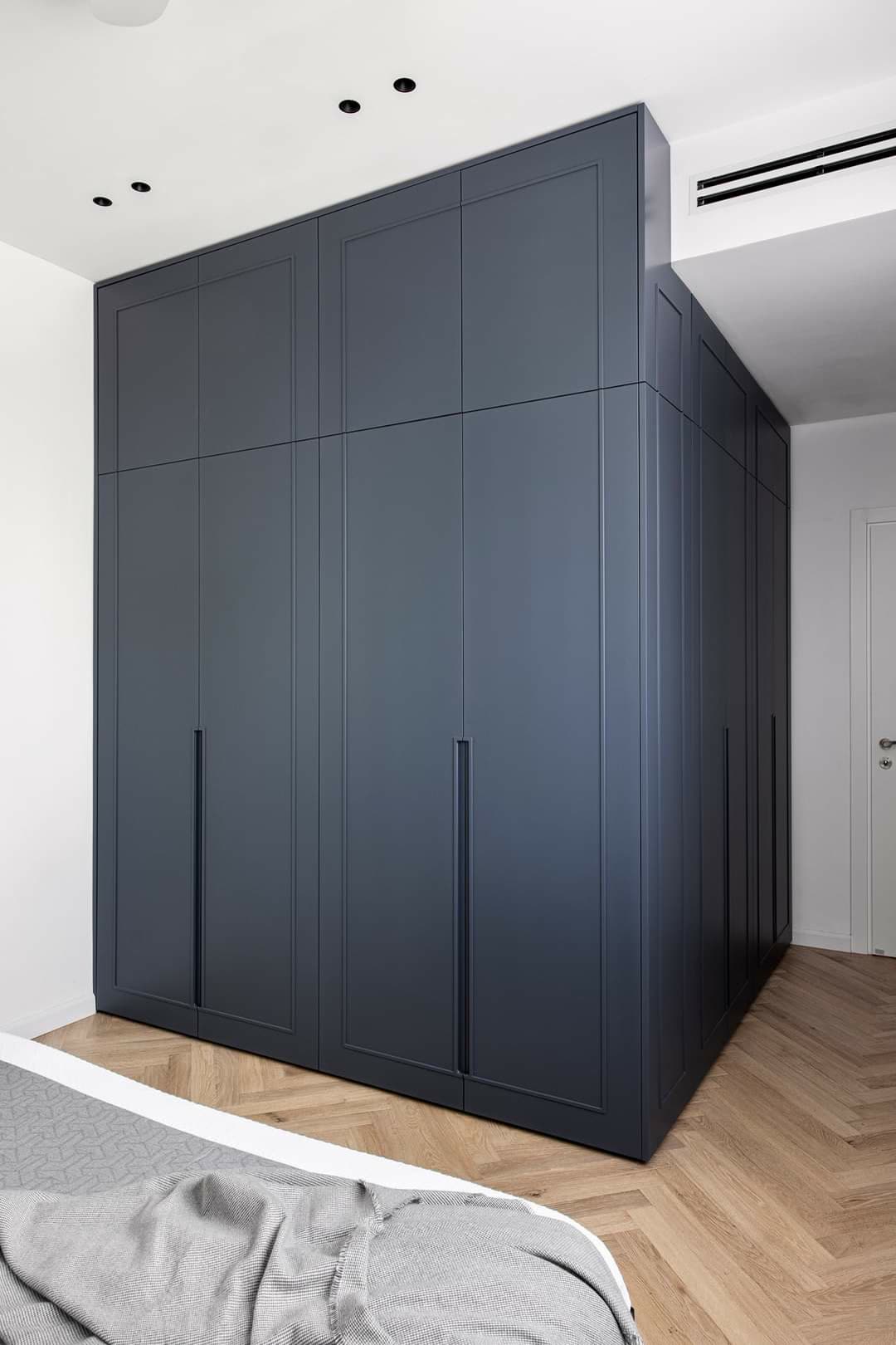 Navy custom wardrobe system with paneled doors by iKitchen Cabinetry