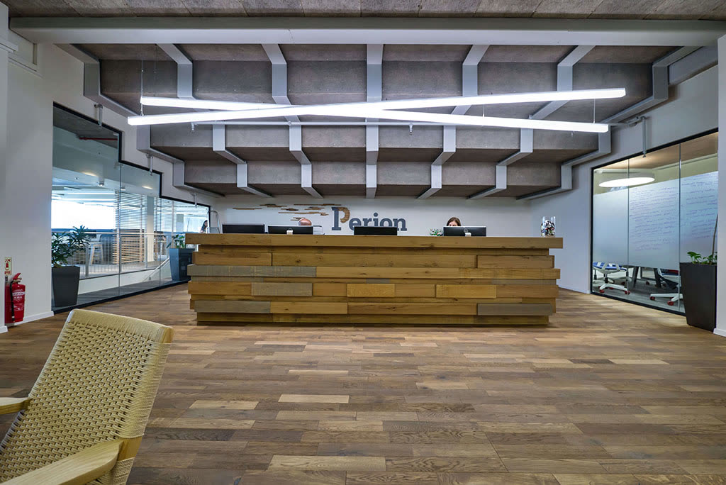 Custom reception desk millwork with a warm wood front and integrated lighting in an office lobby