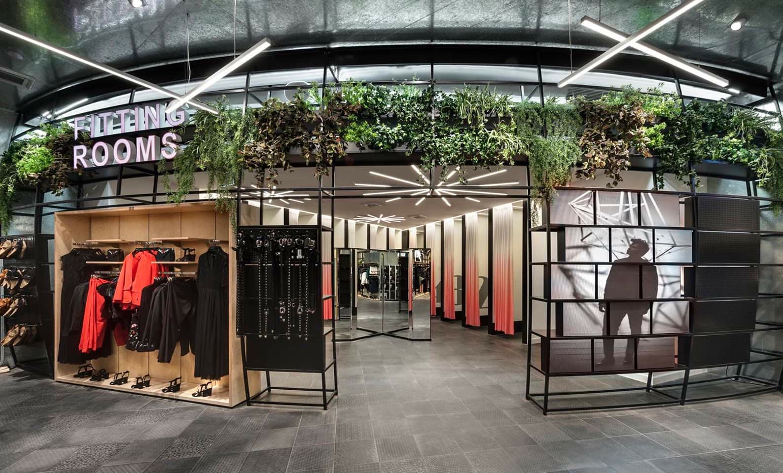 Retail fitting rooms with custom millwork fixtures and greenery by iKitchen Cabinetry