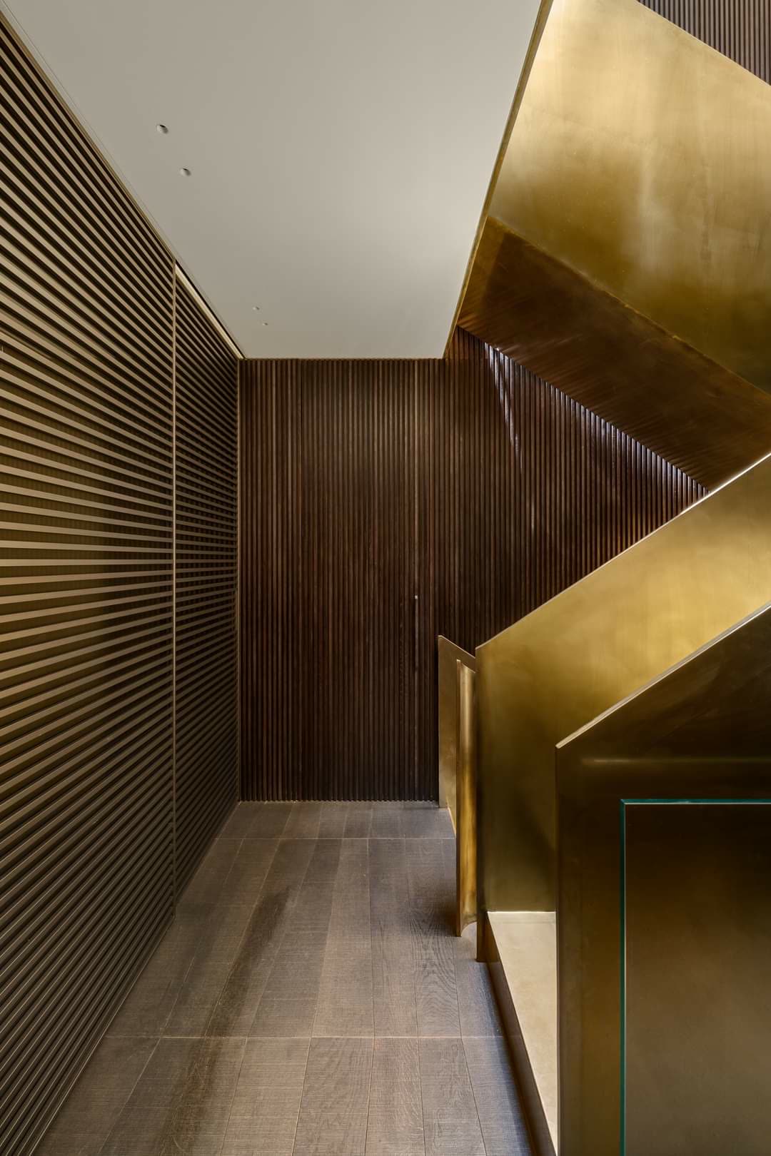 Sculptural brass staircase custom-fabricated by iKitchen Cabinetry