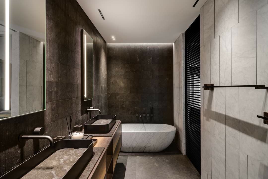 Custom vanity with a full stone countertop and integrated undermount sink in a modern bathroom