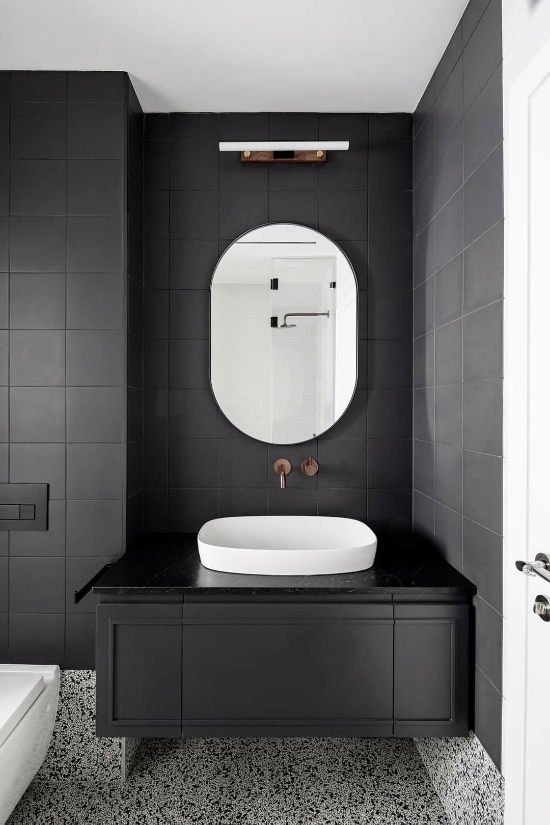 Compact powder room vanity with a statement stone top and dramatic dark cabinetry